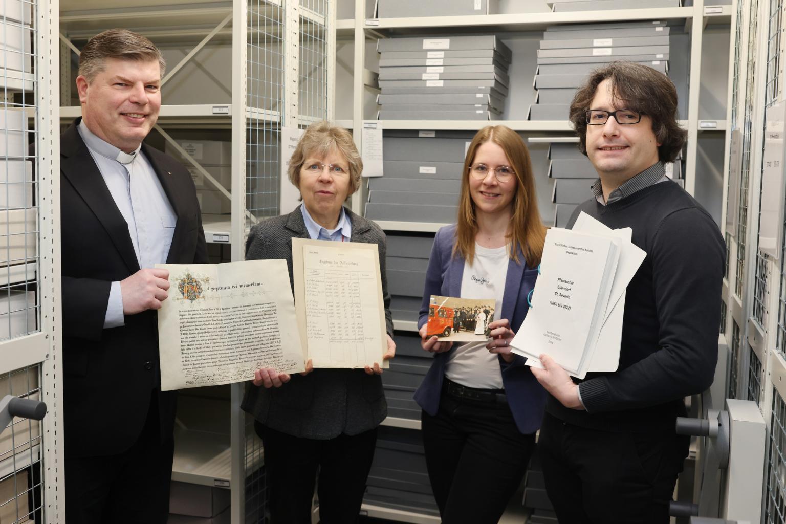 Angekommen im „Gedächtnis des Bistums Aachen“: Über die sichere Lagerung der Pfarrarchive und die Übergabe der Findbücher freuen sich (von links) der Eilendorfer Pfarrer Alexius Puls, Diözesanarchivdirektorin Dr. Beate Sophie Fleck, Referentin für Pfarrarchivpflege Katharina Amfalder sowie Juliano de Assis Mendonça, Archivberater beim Landschaftsverband Rheinland (LVR).  Foto: Bistum Aachen/Andreas Steindl (c) Bistum Aachen/Andreas Steindl