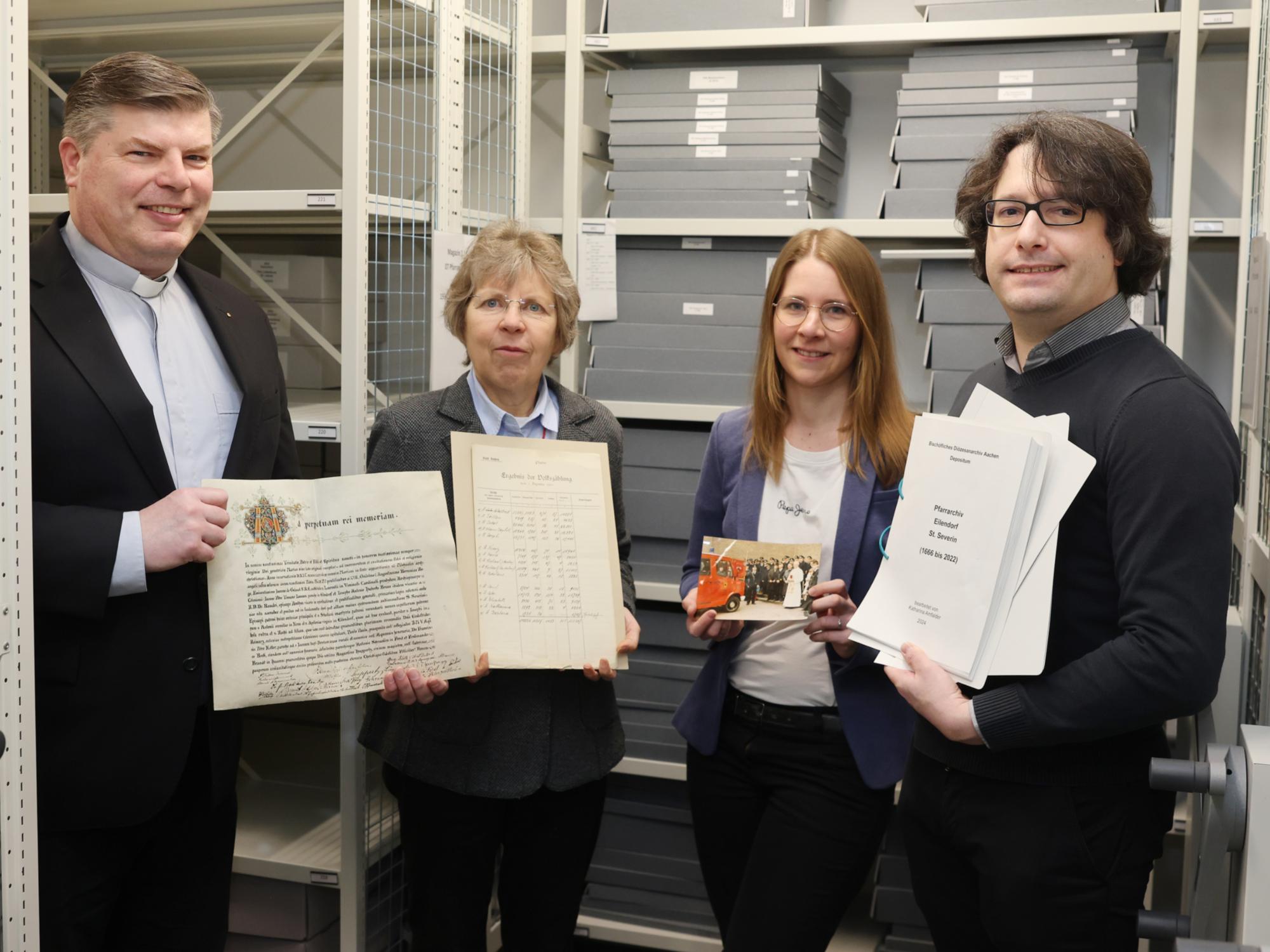 Angekommen im „Gedächtnis des Bistums Aachen“: Über die sichere Lagerung der Pfarrarchive und die Übergabe der Findbücher freuen sich (von links) der Eilendorfer Pfarrer Alexius Puls, Diözesanarchivdirektorin Dr. Beate Sophie Fleck, Referentin für Pfarrarchivpflege Katharina Amfalder sowie Juliano de Assis Mendonça, Archivberater beim Landschaftsverband Rheinland (LVR).  Foto: Bistum Aachen/Andreas Steindl