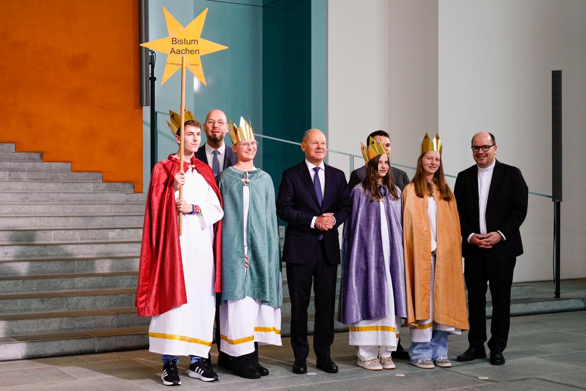 Zum Gruppenfoto mit dem Kanzler stellten  sich die Sternsinger aus Viersen gemeinsam mit Pfarrer Dirk Bingener, Präsident des Kindermissionswerks ‚Die Sternsinger‘, und Domvikar Stefan Ottersbach, Bundespräses des Bundes der Deutschen Katholischen Jugend (BDKJ), im Bundeskanzleramt auf. (c) Friedrich Stark / Kindermissionswerk