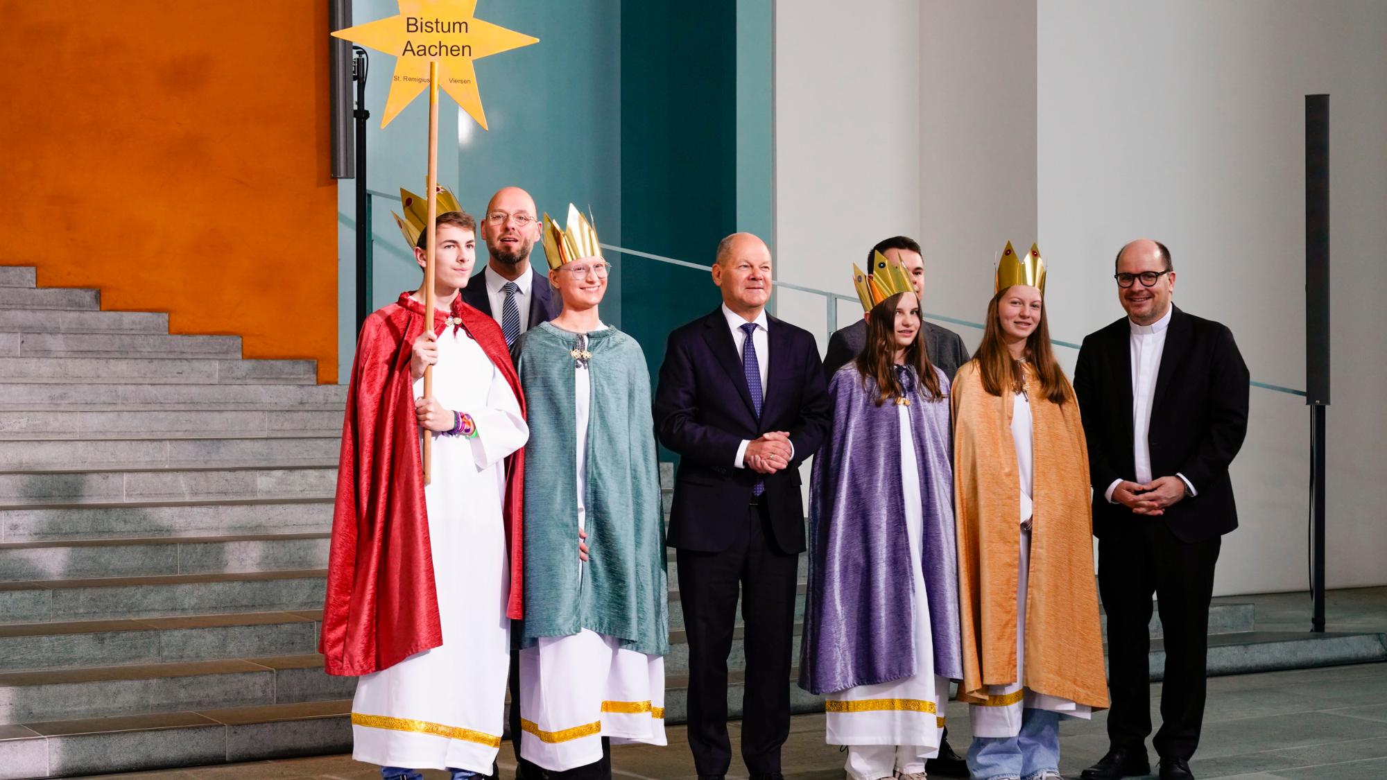 Zum Gruppenfoto mit dem Kanzler stellten  sich die Sternsinger aus Viersen gemeinsam mit Pfarrer Dirk Bingener, Präsident des Kindermissionswerks ‚Die Sternsinger‘, und Domvikar Stefan Ottersbach, Bundespräses des Bundes der Deutschen Katholischen Jugend (BDKJ), im Bundeskanzleramt auf.