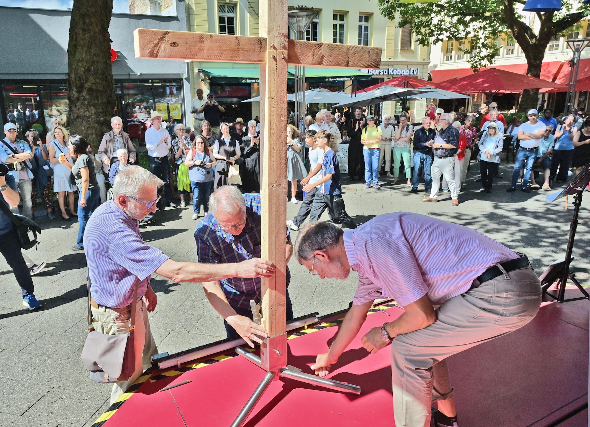 Auf dem Neumarkt werden die vier Kreuzteile, die die Teilnehmer der vier Wallprozessionen getragen haben, zusammengesetzt.