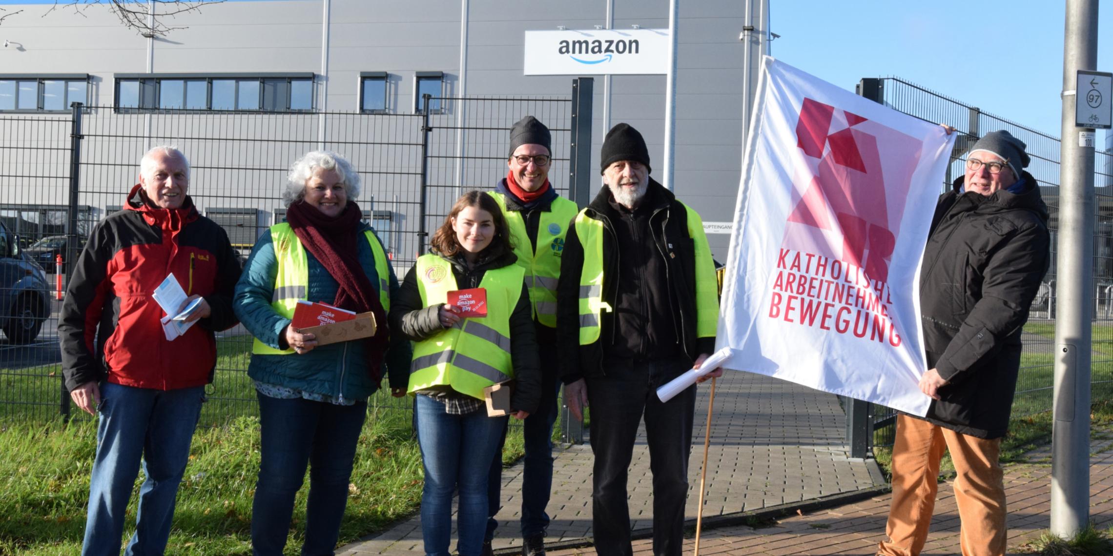 Vereinte Solidarität zum Black Friday 2022 vor dem Amazon-Verteilzentrum im Gewerbegebiet zwischen Aachen und Heerlen. Von links nach rechts: Heinz Backes, Ursula Rohrer, Anna Schlecht, Dr. Manfred Körber, Andris Gulbins und Hans-Werner Quasten.